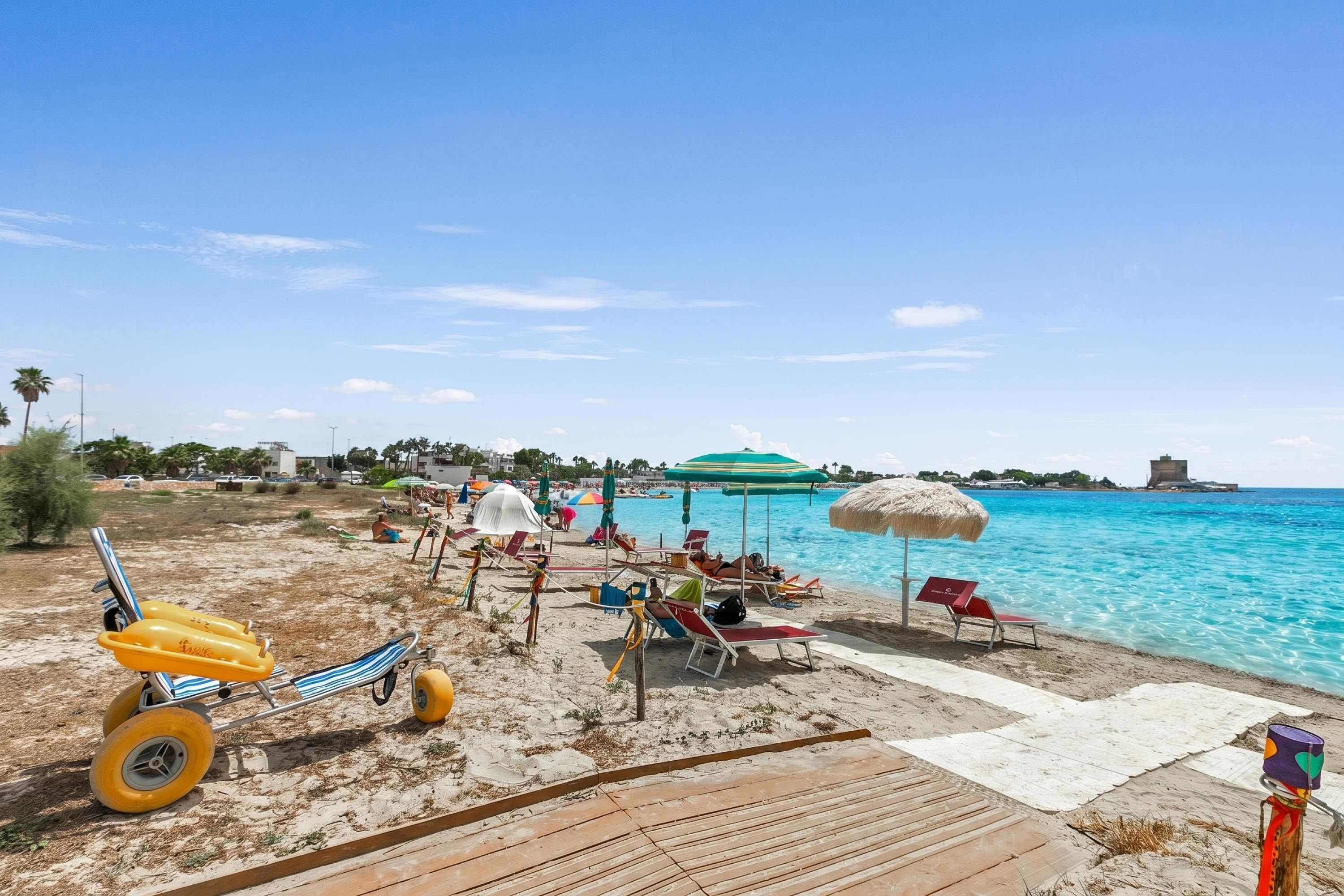 A beach with a wooden deck, beach chairs, umbrellas, and a yellow toy car.
