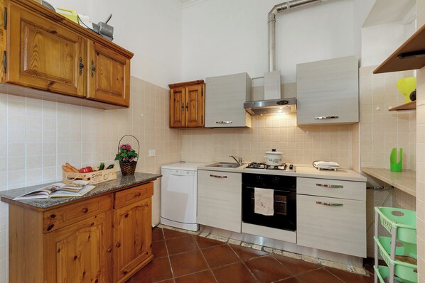 A kitchen with wooden cabinets, a dishwasher, a stove, and a sink. - Villa Isidoro - Sea View and Garden, 50m to Beach (Nardò)