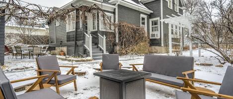 A house with a covered patio area featuring outdoor furniture and a snow-covered yard.