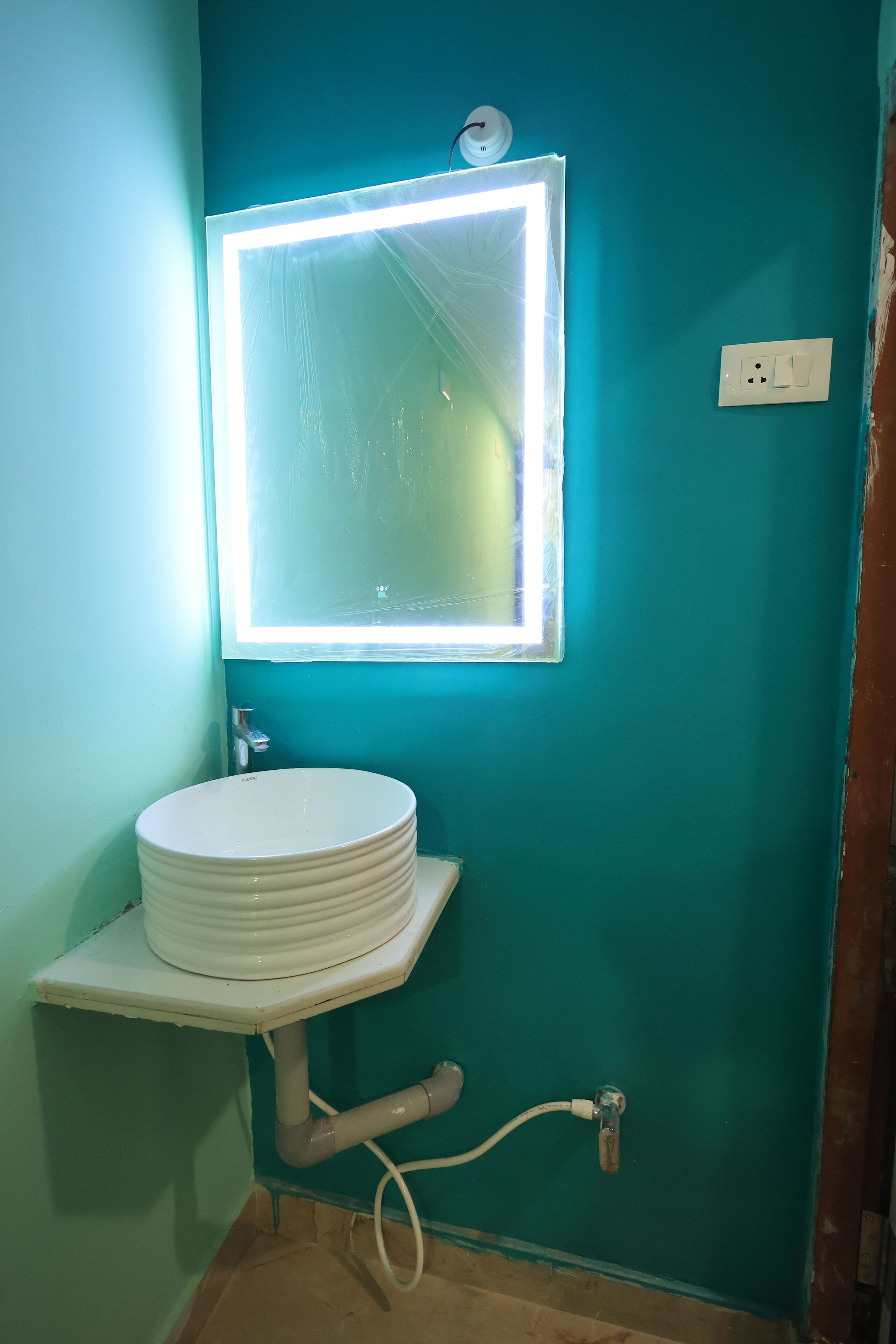 A bathroom with a white sink, a mirror, and a light fixture.