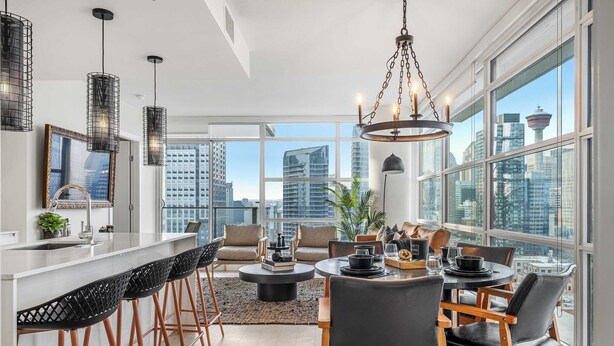 Una cocina moderna con barra, ventanas amplias y vistas a la ciudad.