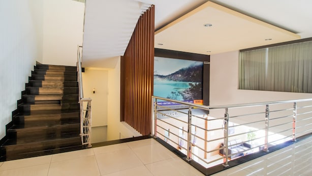Un interior moderno con una escalera, un televisor de pantalla plana grande y un balcón con vistas.
