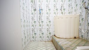 A bathroom with floral wallpaper, a radiator, and a tiled floor. - Hotel O Kost Berkah Near Kebun Teh Wonosari (Malang)