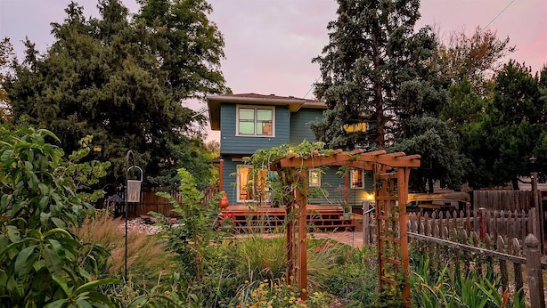 A house with a wooden deck and a garden.