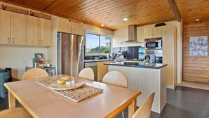 Een moderne keuken met houten kastjes, roestvrijstalen apparatuur en een centraal eiland met zitplaatsen.
