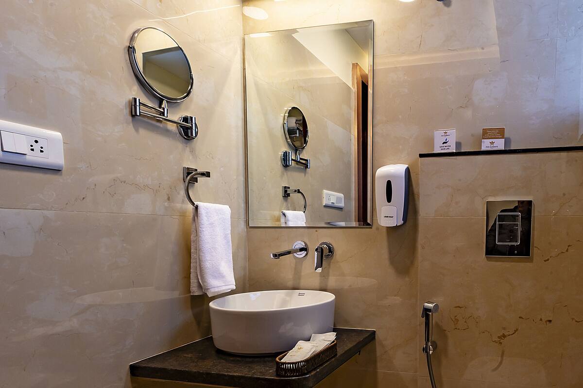 Ein modernes Badezimmer mit Waschbecken, Spiegel, Handtuchhalter und Toilette.