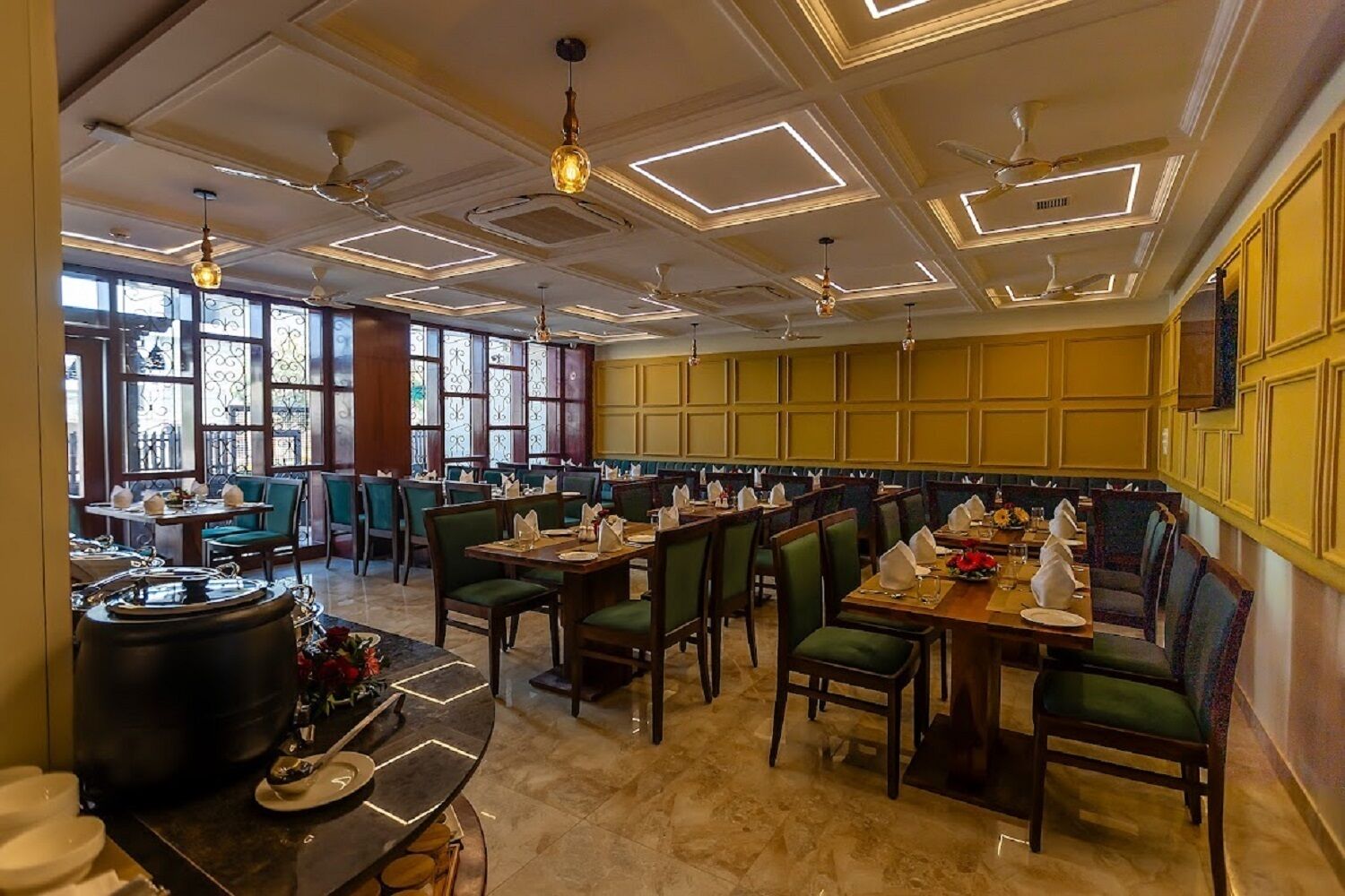 A restaurant with a classic interior, featuring wooden tables and chairs, a marble floor, and a decorative ceiling with recessed lighting.