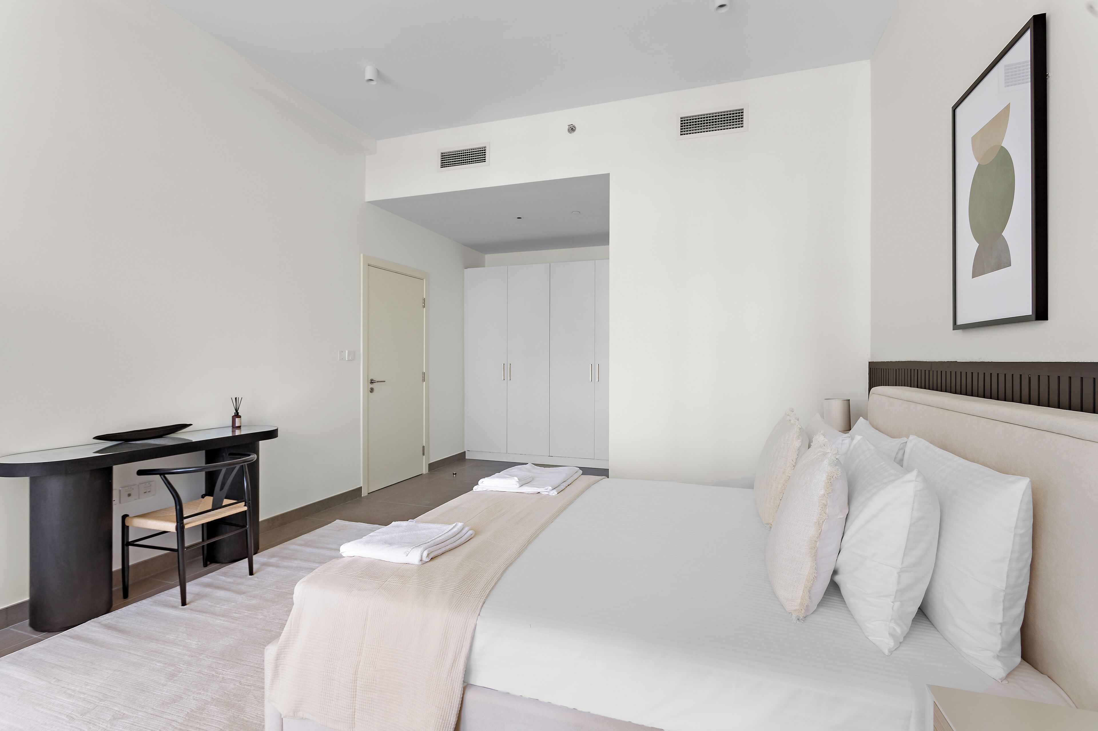 Une chambre d’hôtel moderne, équipée d’un lit, d’un bureau et d’une chaise.