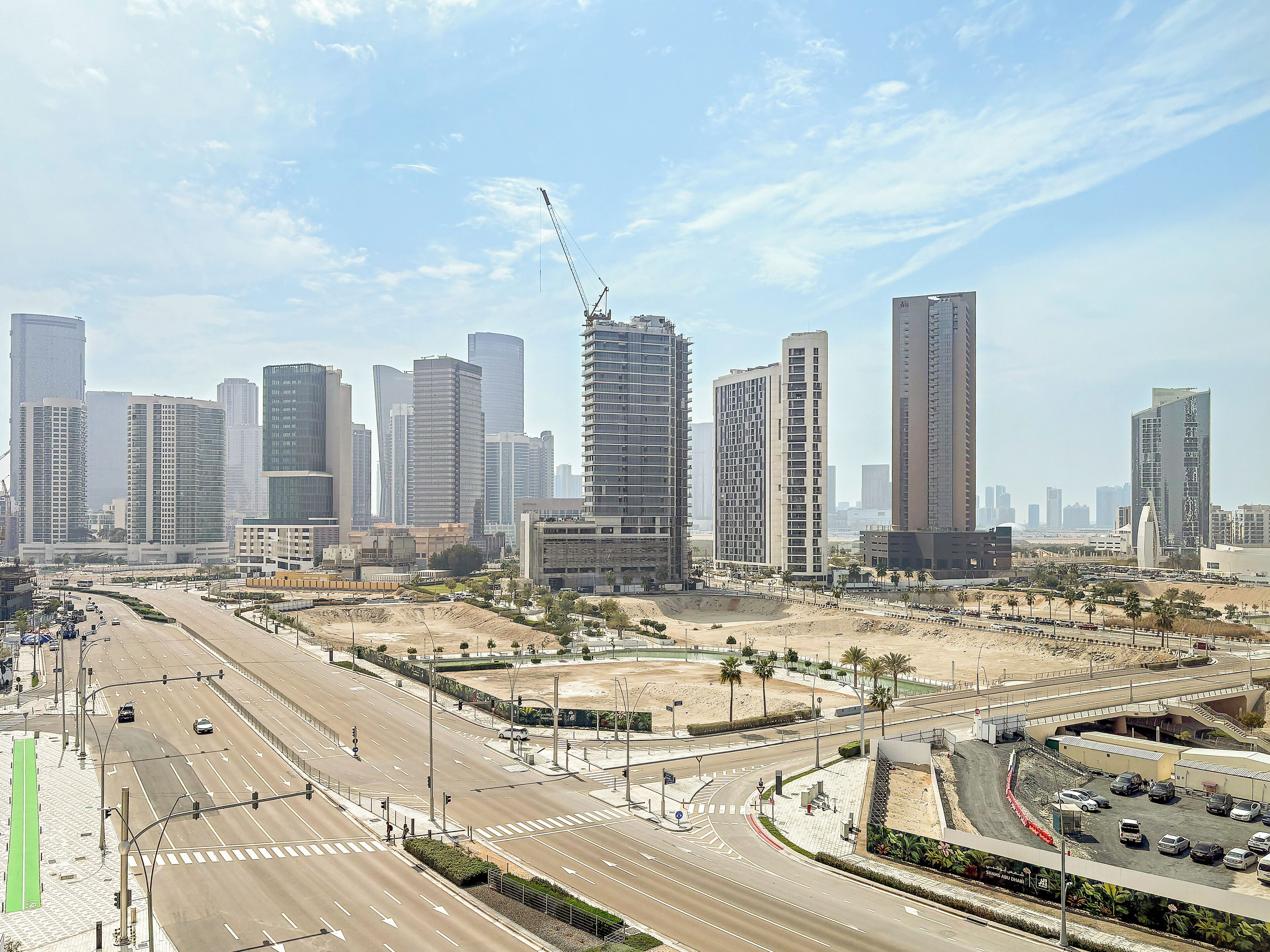 A cityscape with modern high-rise buildings, a busy intersection, and a construction site.