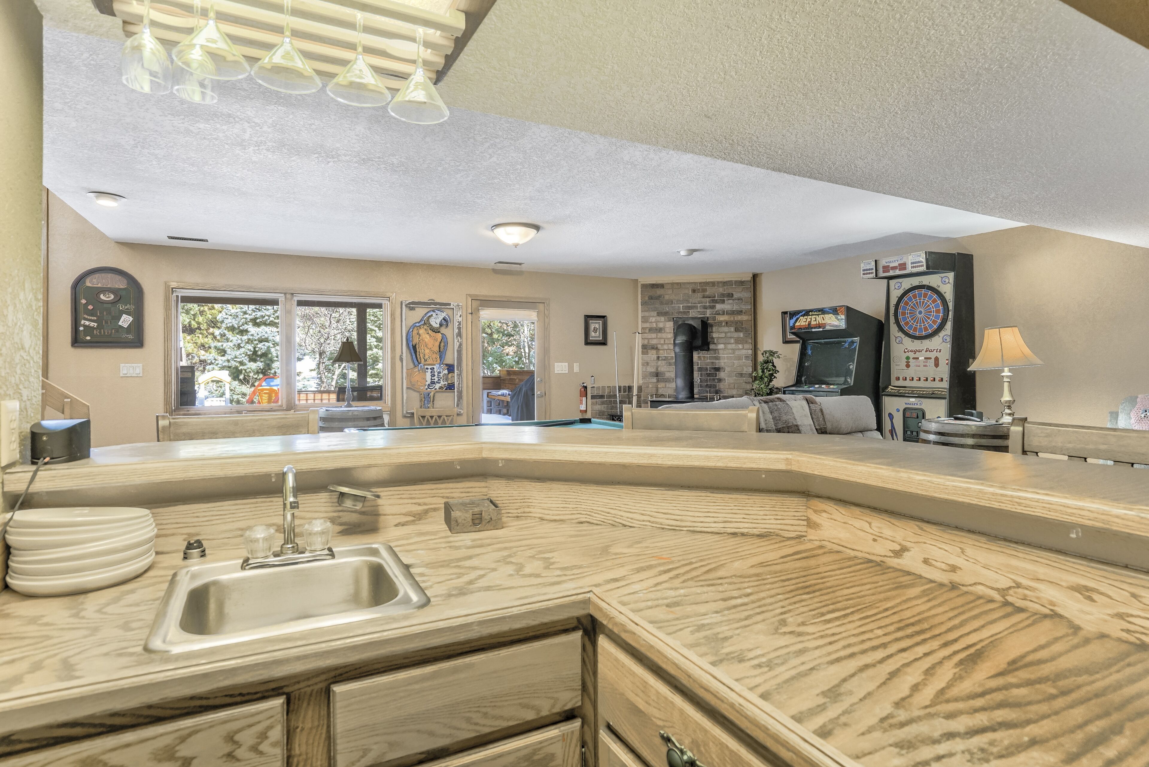 Uma cozinha moderna com uma ilha grande, forno embutido e área de refeições com sofá e mesa.