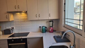 Eine moderne Küche mit Einbauherd, Wasserkocher, Mixer und Spüle.