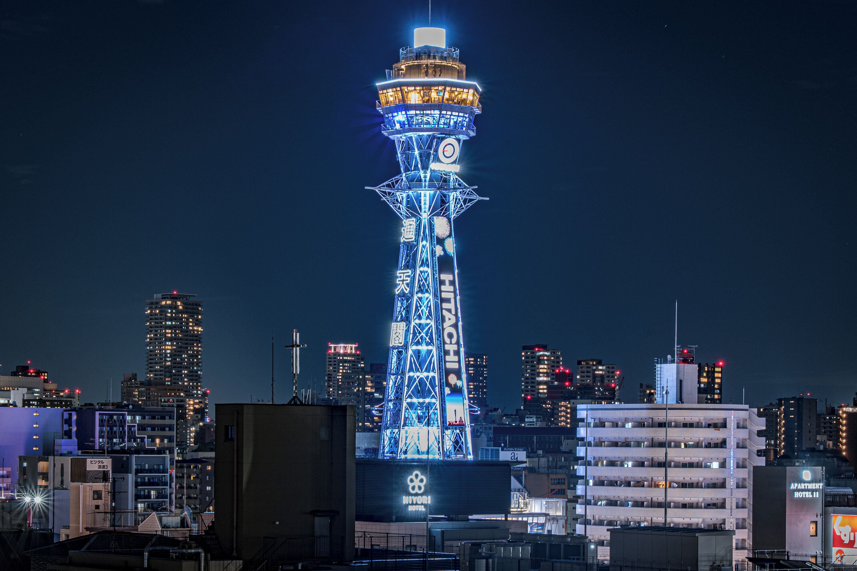 Una torre alta con un reloj en la parte superior, rodeada de edificios urbanos.