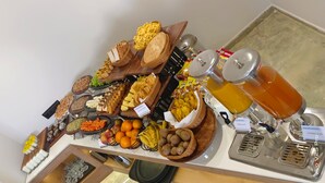 A buffet with various food items and beverages, including fruits, vegetables, and condiments. - Regenta Inn Motikhavdi Jamnagar  (Jamnagar)