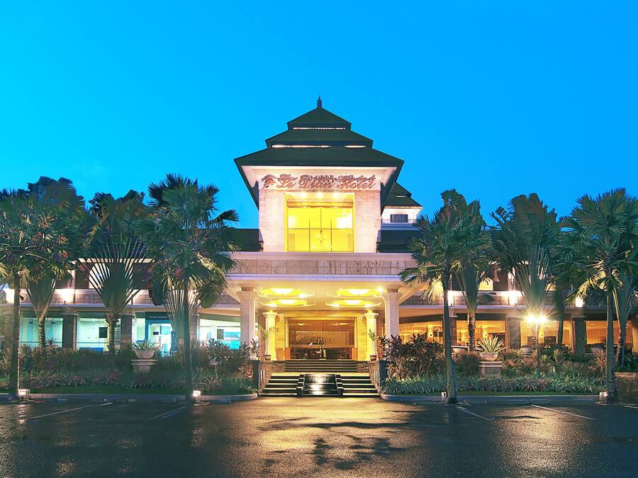 A hotel entrance with a prominent tower and a well-lit facade.