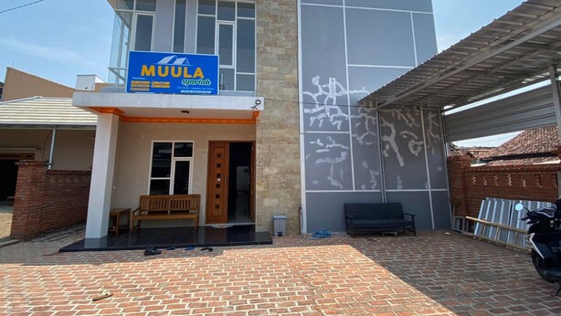 Ein modernes Gebäude mit einem Schild für Gartenmöbel von MUULA.