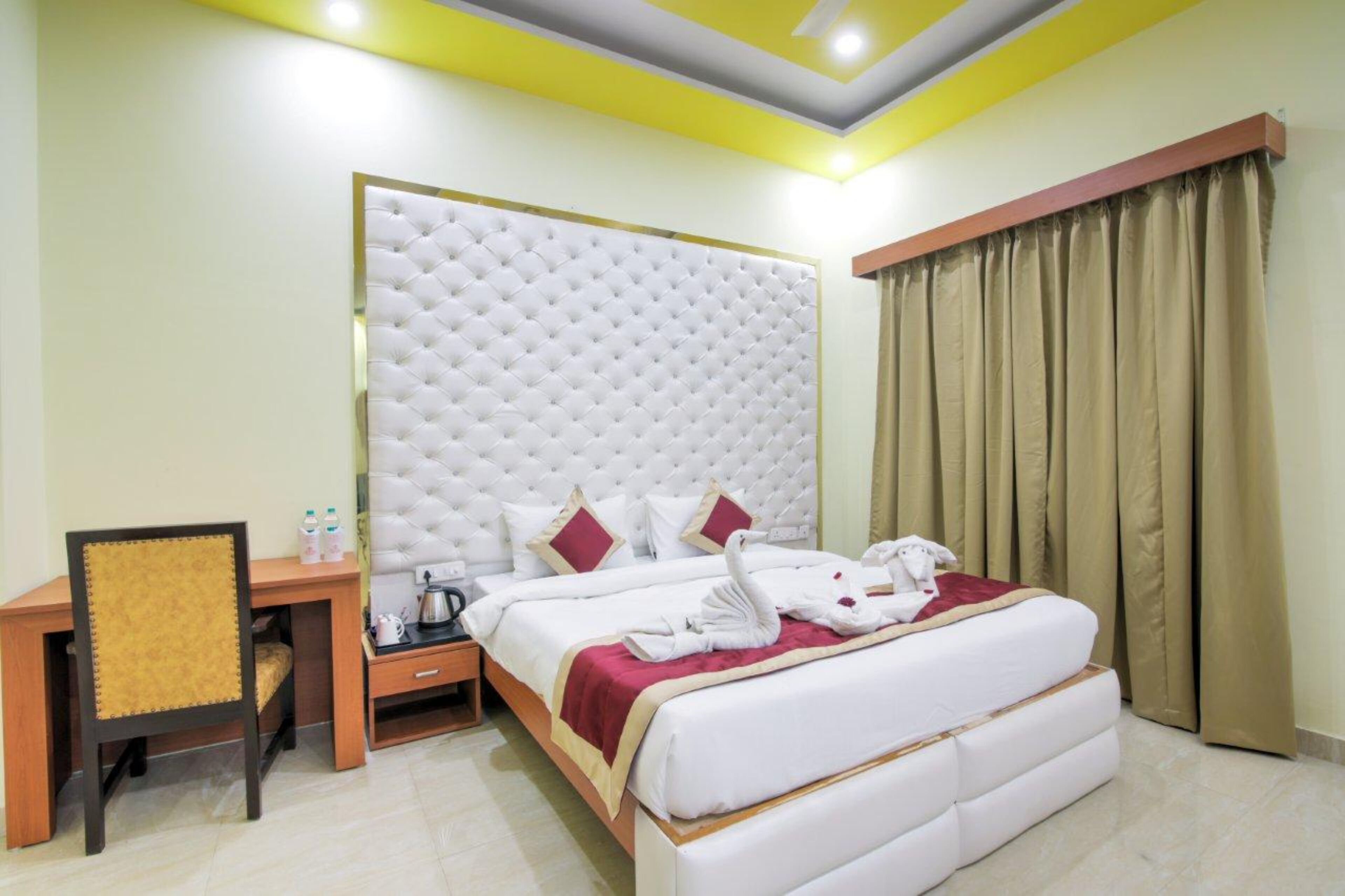 A hotel room with a large bed, a desk, and a chair.
