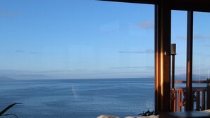 A living room with a view of the ocean. - Waterfront beach house overlooking one of Tassie's favourite surf breaks (Dodges Ferry)