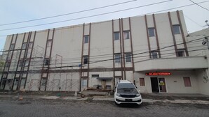 Un bâtiment sur lequel on peut lire l’inscription « SELANGAT DATANG II », avec une voiture blanche garée devant.