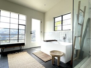 A modern bathroom with a large bathtub, a wooden stool, and a glass shower enclosure. - Cozy Retreat on The Santa Monica Mountains  (Topanga)