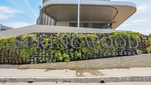 A modern building with a curved facade and a sign that reads "SPRINGWOOD Residence". - OYO 93447 City Rooms Apartment (Tangerang)