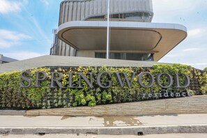 A modern building with a curved facade and a sign that reads "SPRINGWOOD Residence". - OYO 93447 City Rooms Apartment (Tangerang)