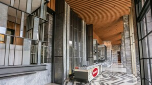 A modern lobby with a reception desk, marble flooring, and large windows. - OYO 93447 City Rooms Apartment (Tangerang)