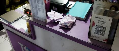 A counter with a laptop, papers, and a QR code.