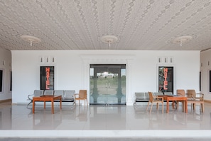 A hotel lobby with a modern design, featuring a patterned ceiling, a reception desk, and seating arrangements.