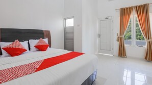 A hotel room with a large bed, white walls, and a window with curtains. - Hotel O Wisma Silampari (Lubuklinggau)