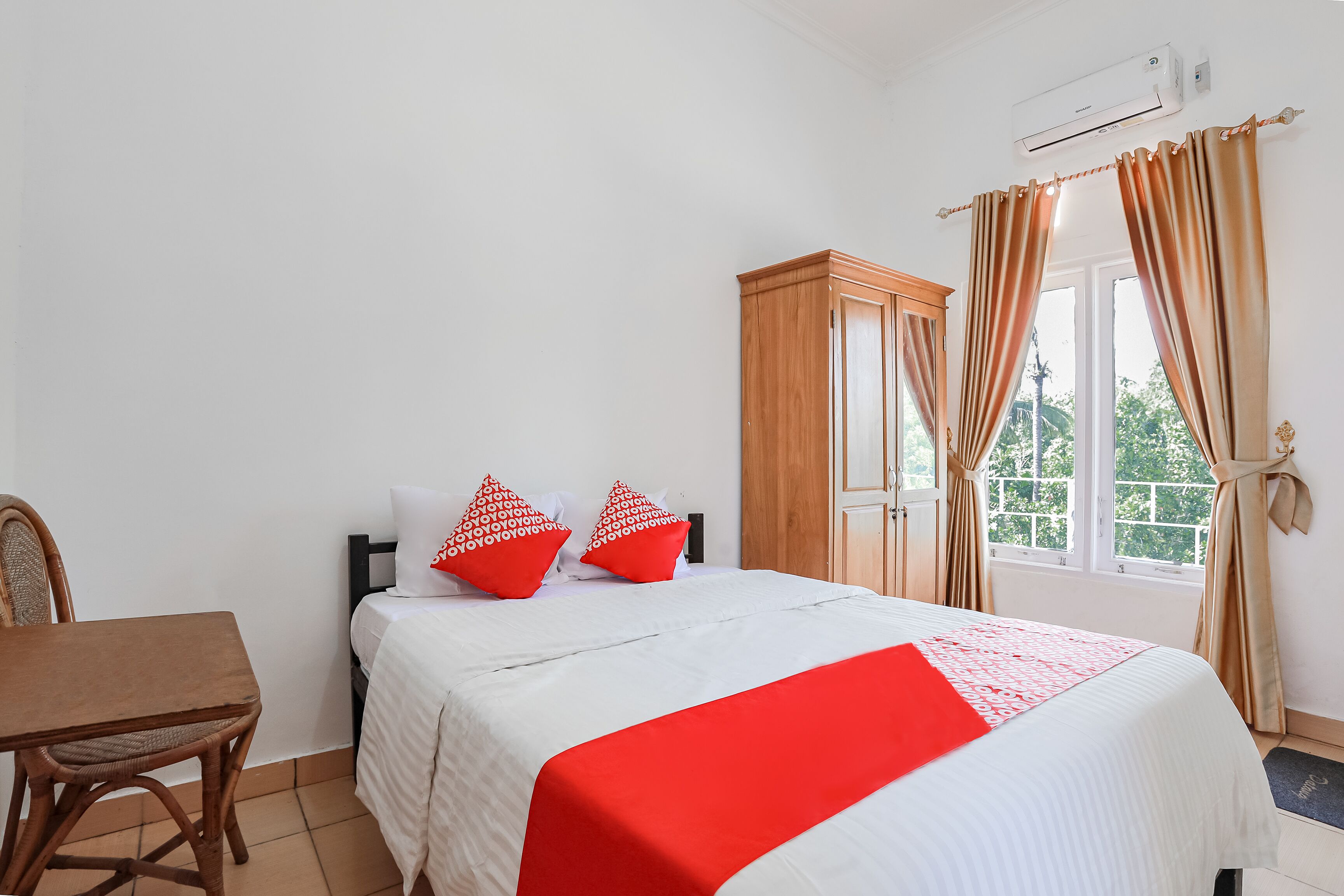Une chambre à coucher avec un lit, une armoire en bois, une table et une chaise.