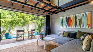 Un salon moderne avec un grand canapé, une table basse et un tableau abstrait aux couleurs vives accroché au mur.