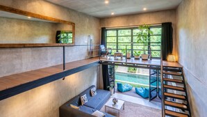 Un intérieur moderne au design de type « loft », comprenant une mezzanine, un escalier et une vue sur un jardin.