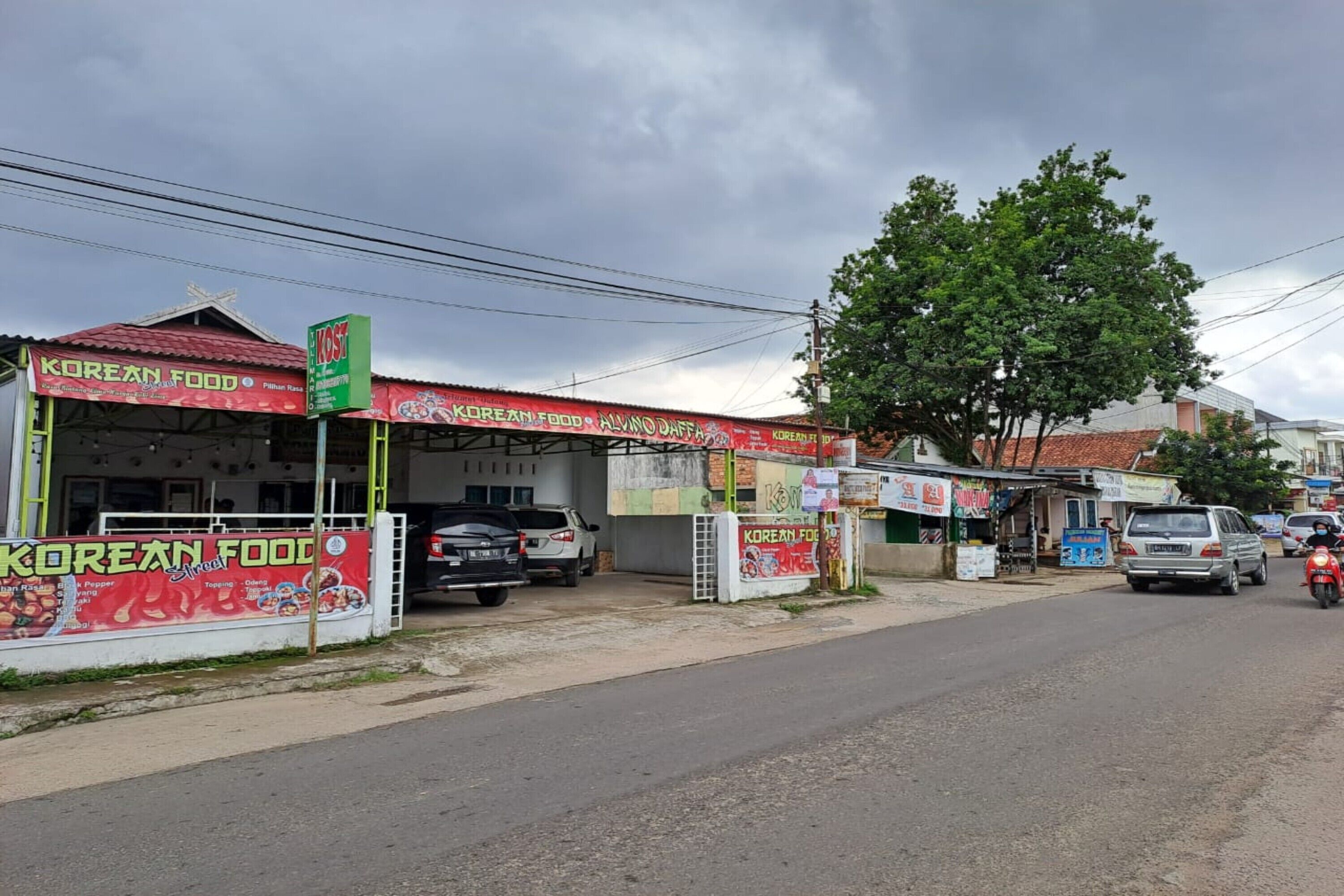 A street view with a Korean food restaurant and a signboard advertising 'Korean Food'.