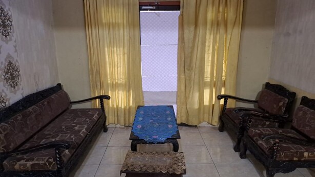 Una habitación con dos sofás, una mesita y una cortina estampada.