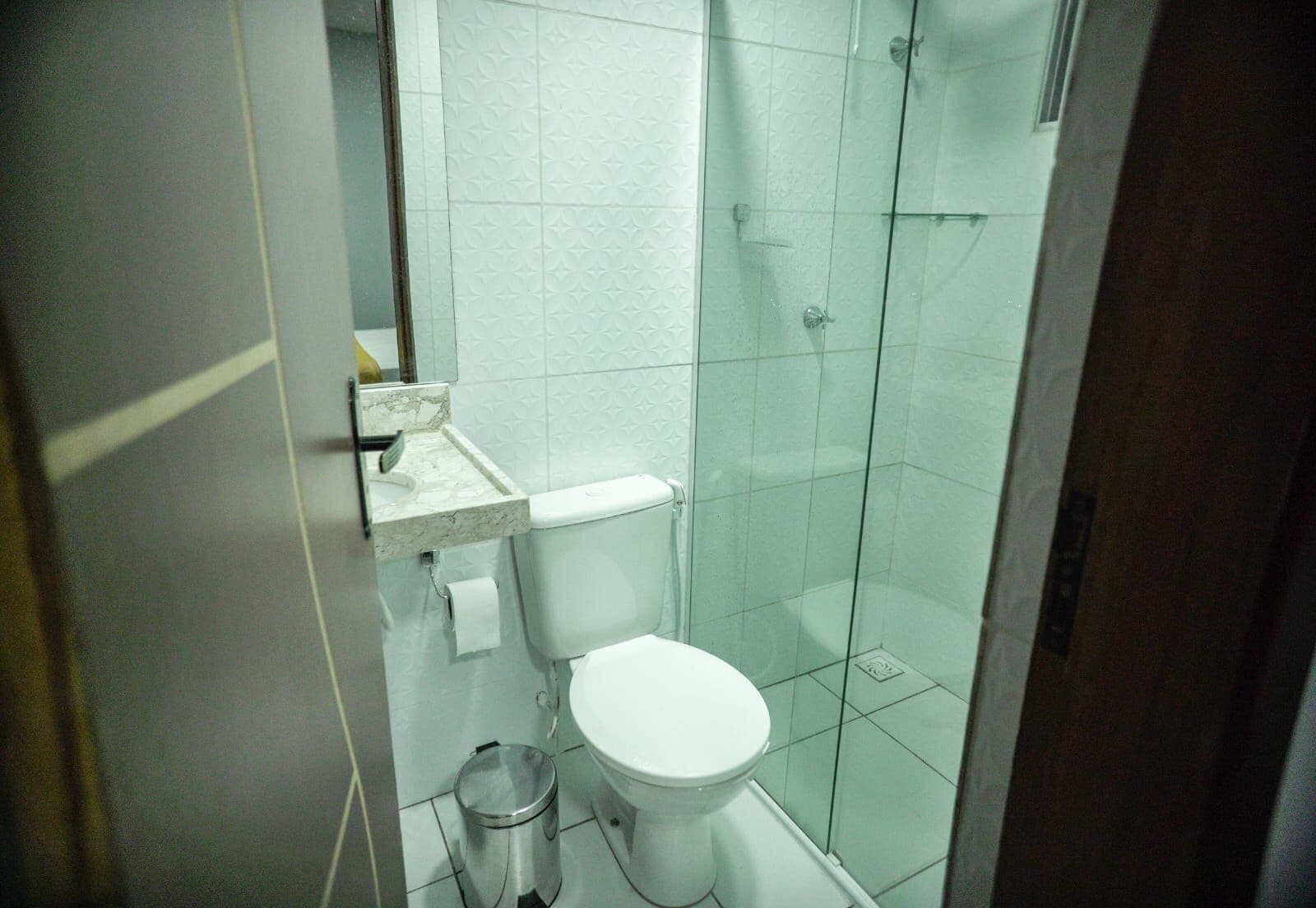 Une petite salle de bain moderne équipée de toilettes, d’un lavabo et d’une douche.