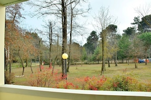A view of a park with trees, a lamp post, and a grassy area. - Colourful Seaside Flat With Pool on the Rooftop (San Michele al Tagliamento)
