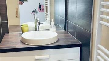 Een haardroger, handdoeken, zeep, toiletpapier