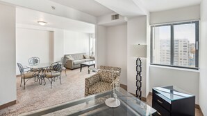 A modern living room with a glass coffee table, a patterned armchair, a sofa, and a dining area with a table and chairs. - This apartment is a 1 bedroom(s), 1 bathrooms, located in Harrisburg, PA. (Harrisburg)