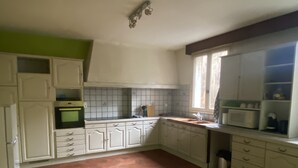 Eine Küche mit weißen Schränken, einer gefliesten Spritzschutzwand und einem Boden mit sechseckigem Muster.
