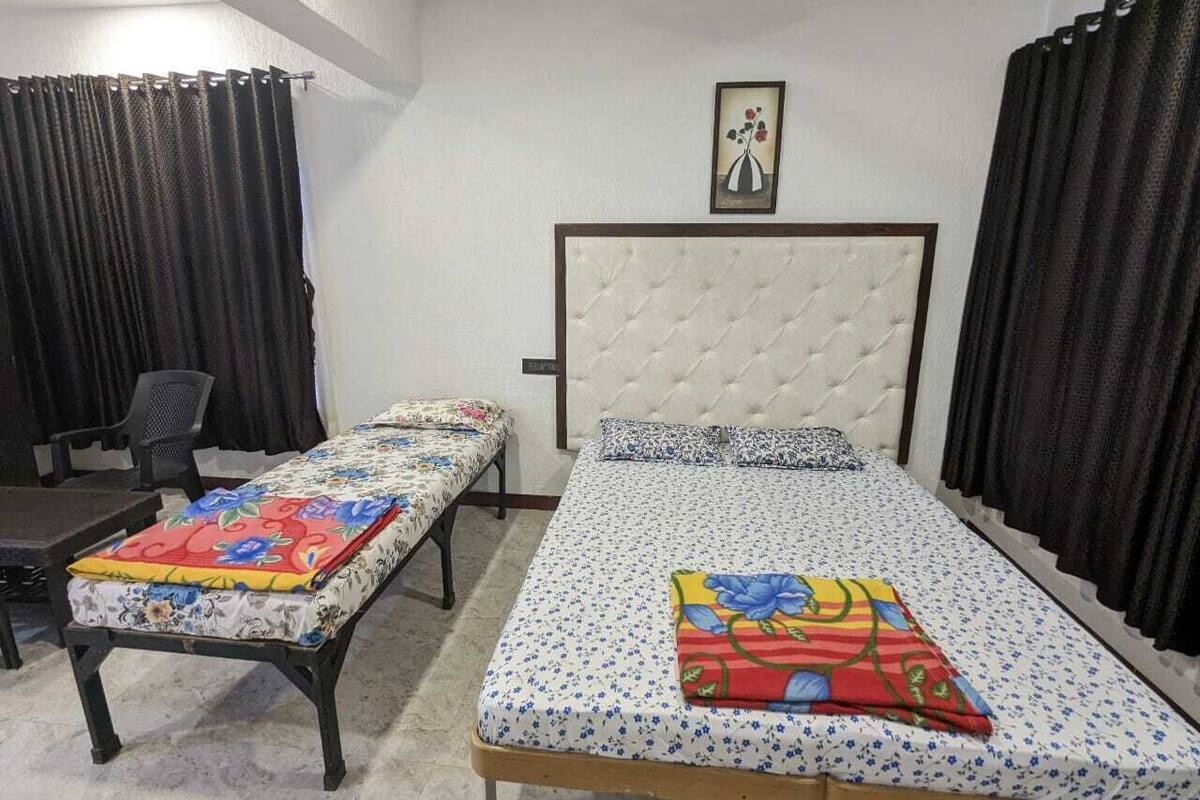A bedroom with two single beds, a chair, and a small table.