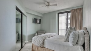 A bedroom with a bed, a ceiling fan, a TV, and a view of the outside. - Summer House 806B | Sleeps 10 | 3BR | 2BA (Orange Beach)
