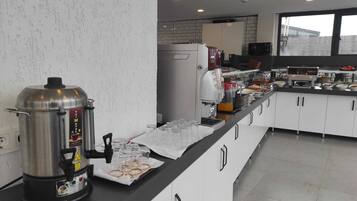 A modern kitchen with a coffee station, a large pot, and a refrigerator.