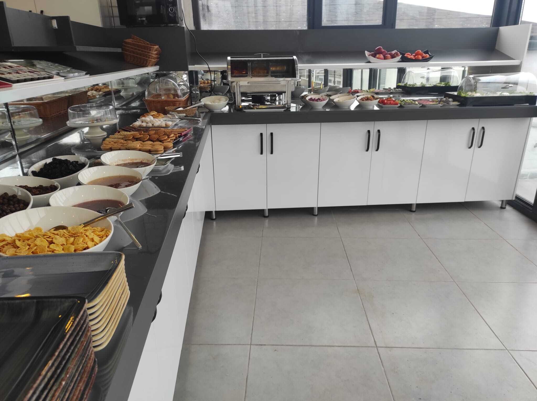 A buffet area with various food items and a self-service station.
