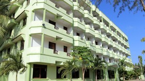 A multi-story building with balconies and windows, surrounded by palm trees. - Greenyard Resort Mtwapa (Mtwapa)