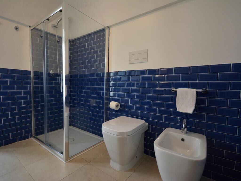 Un baño con cabina de ducha de vidrio, inodoro y bidé.