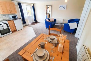 A compact living space with a kitchen, dining area, and seating area. - Captivating 1-bed Apartment in Stroud (Stroud)