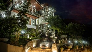 A multi-story modern house with a car parked in front.