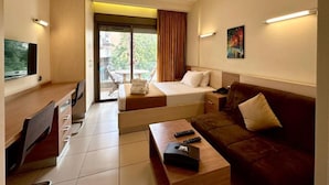 A hotel room with a bed, a sofa, a desk, and a TV. - Digit nomad by List buddy (Jounieh)