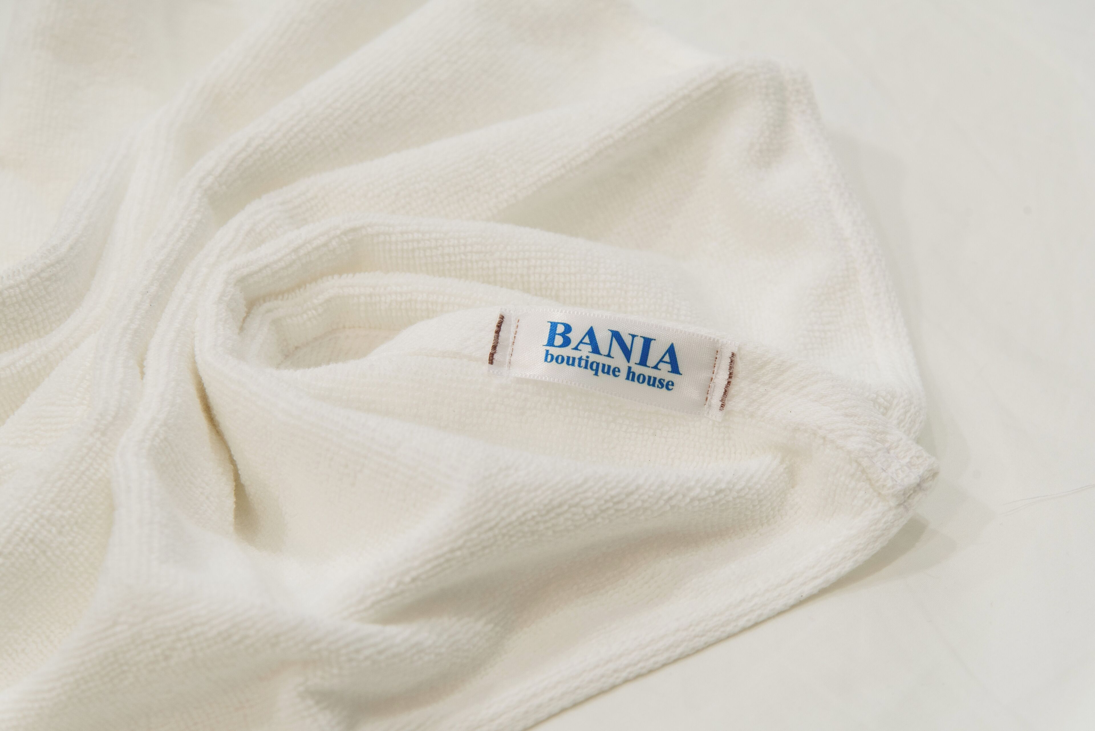 Een witte stof met een label waarop staat 'BANIA boutique house'.