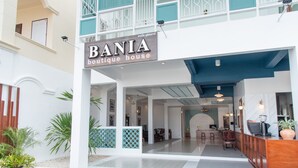 Um hotel boutique chamado BANIA, com decoração moderna, uma receção e uma área de estar.